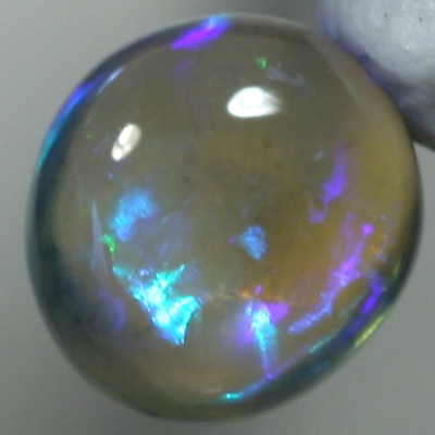 SOLID CRYSTAL OPAL High dome with blue and purple hues throughout the transparent body